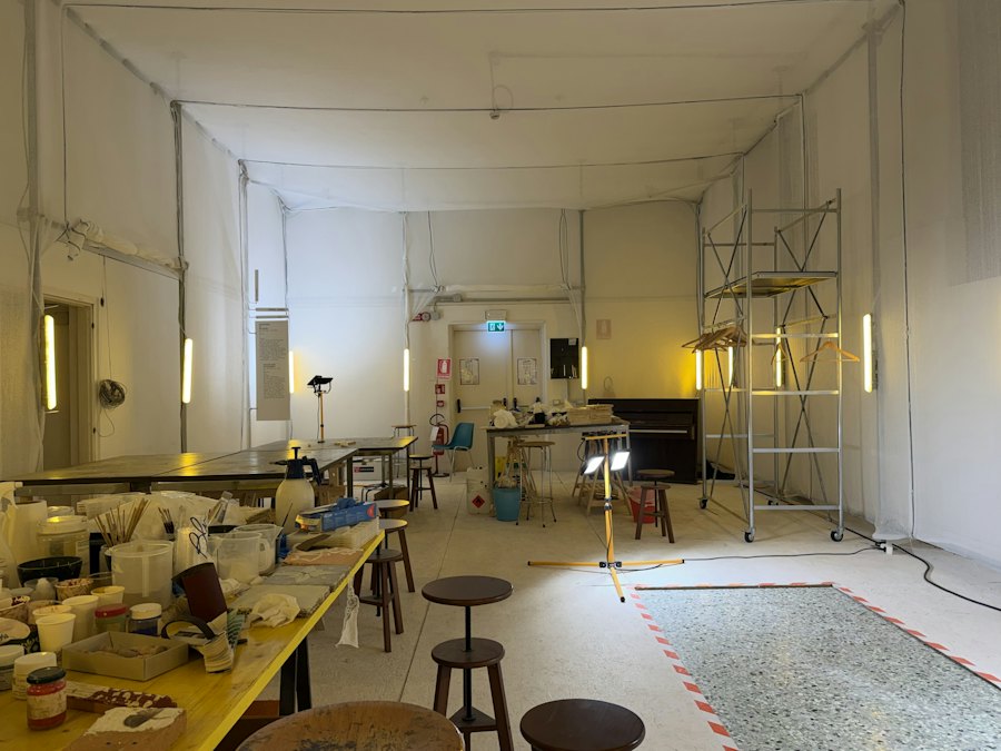 L'atelier : plans de travail, tabourets et pièces en cours.