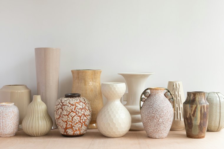 Étagère de vases aux formes et glaçures variées.