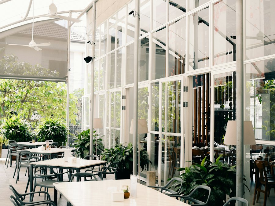 La terrasse du bistrot : tables, chaises et plantes vertes.
