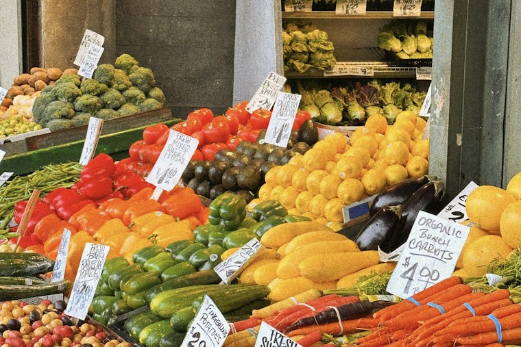 Étal de marché : légumes et fruits rangés par couleurs.